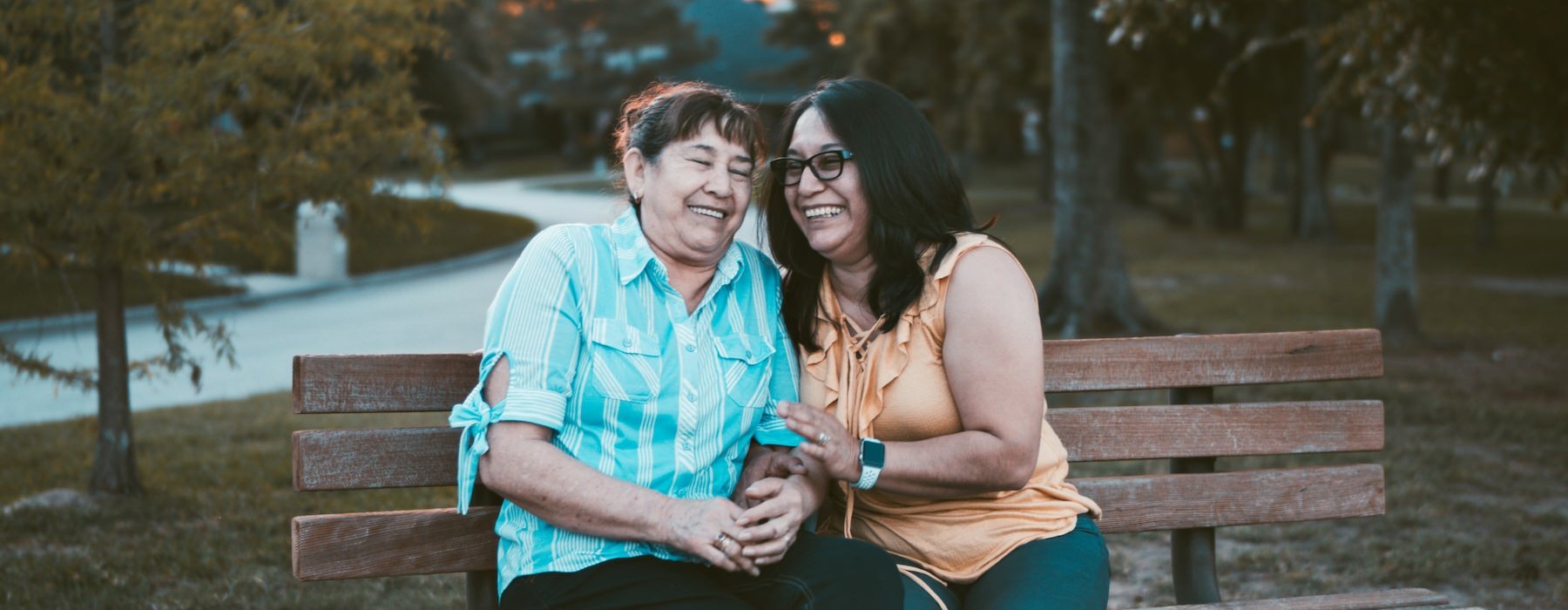 women sitting on a bench and smiling 